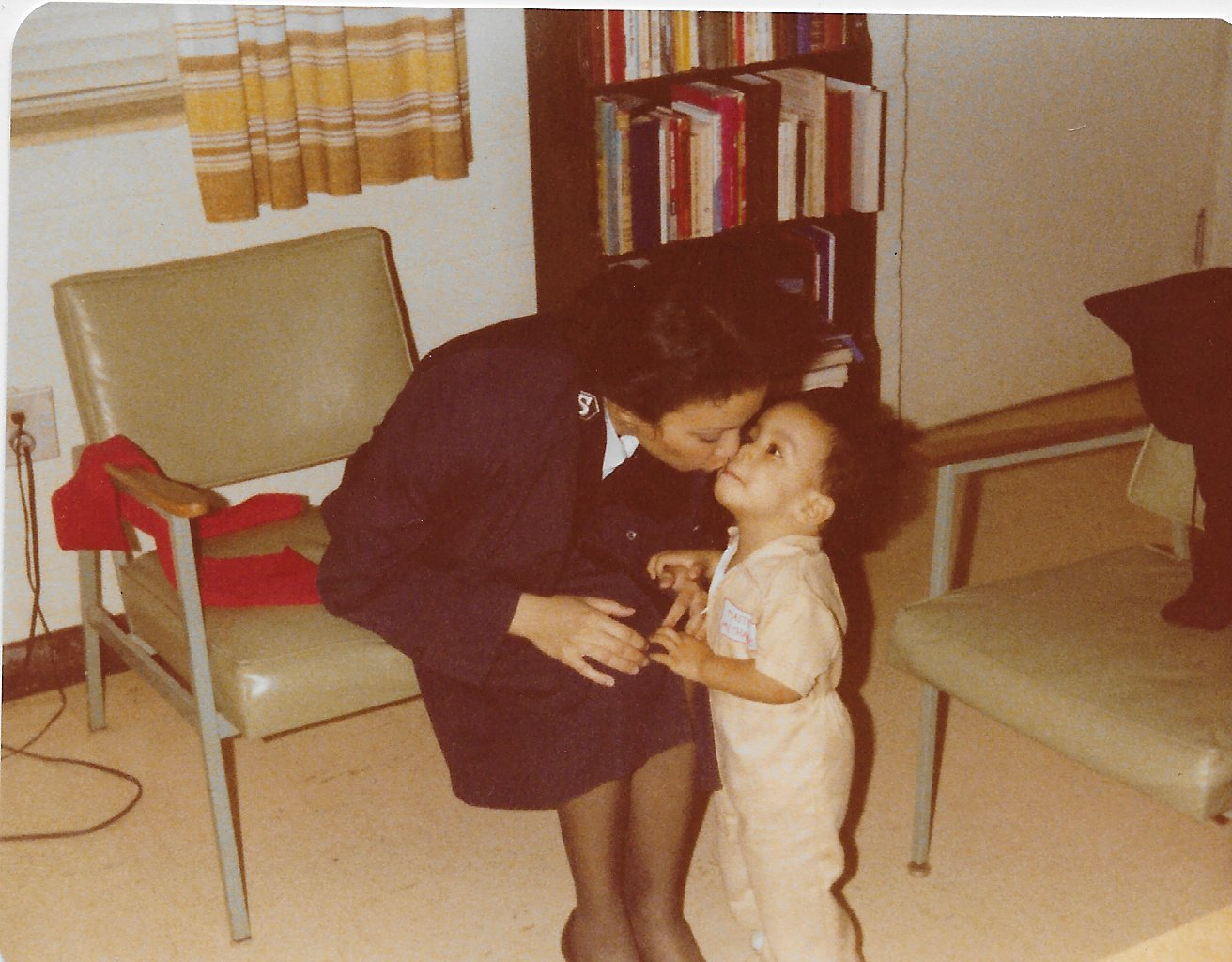 A young mother kissing her son on the forehead